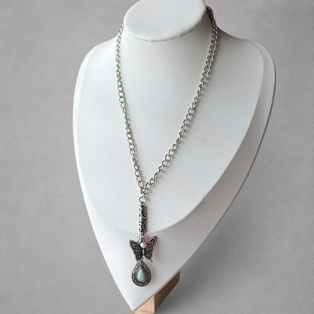 Silver-tone butterfly pendant necklace featuring an ornate butterfly charm .
